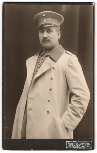 Fotografie Peter M. Michels, Duisburg, Offizier im Mantel mit Schirmmütze und EK II 1914