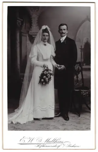 Fotografie E. W. Matthias, Seifhennersdorf i. Sachsen, Elegantes Hochzeitspaar mit Blumenstrauss im Atelier