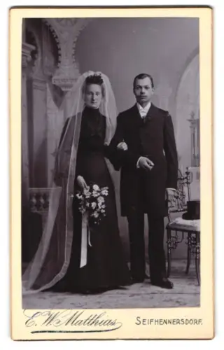 Fotografie E. W. Matthias, Seifhennersdorf, Junges Brautpaar im Atelier mit Blumenstrauss