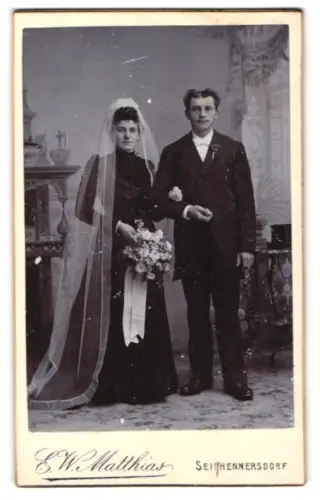 Fotografie E. W. Matthias, Seifhennersdorf, Hochzeitspaar mit Blumenstrauss und Schleier im Atelier