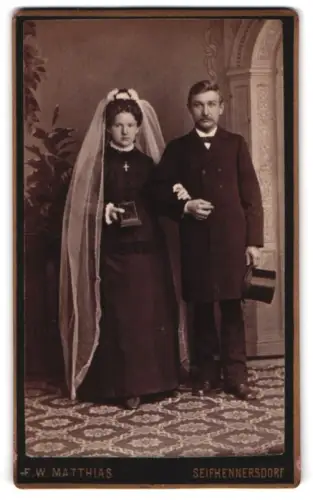 Fotografie E. W. Matthias, Seifhennersdorf, Elegantes Brauparr mit Zylinder und Bibel im Studio