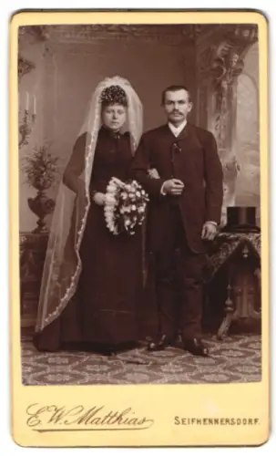 Fotografie E. W. Matthias, Seifhennersdorf, Elegantes Hochzeitspaar mit Blumenstrauss im Studio