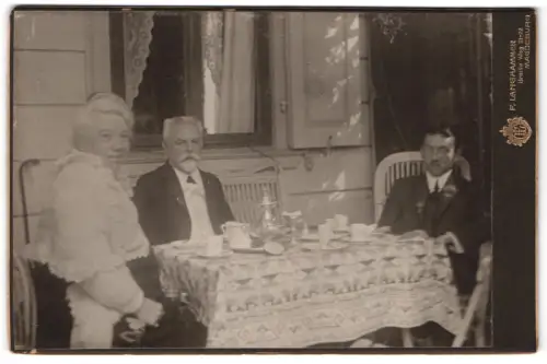 Fotografie F. Langhammer, Magdeburg, Breiter Weg 21-22, Gruppe von drei Personen an einem Tisch zum Tee