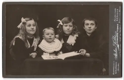 Fotografie Atelier Köthe, Pirmasens, Fröbelgasse 3, Vier elegant gekleidete Kinder mit einem Bilderbuch