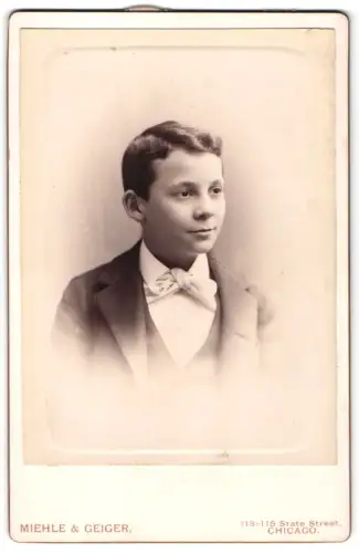 Fotografie Miehle & Geiger, Chicago, 113-115 State Street, Hübscher Knabe im Anzug mit Fliege