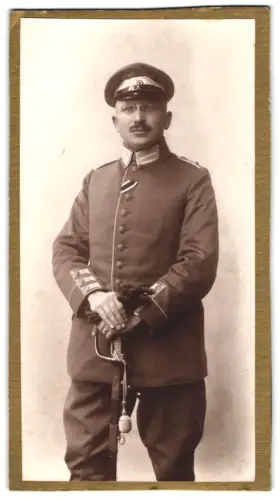Fotografie unbekannter Fotograf und Ort, Leutnant in Uniform mit Band zum EK II 1914, Säbel und Schirmmütze