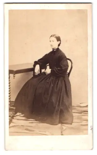 Fotografie unbekannter Fotograf und Ort, Sitzende Frau in schwarzem Kleid