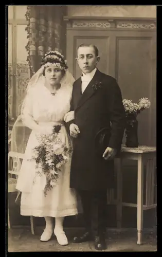 Foto-AK Elegantes Hochzeitspaar neben mit Brautstrauss neben einer Blumenvase