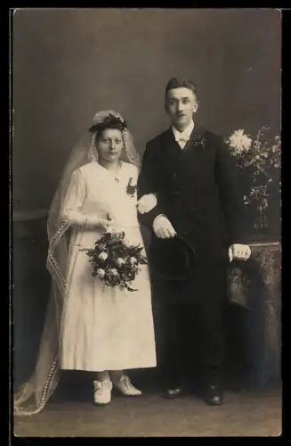 Foto-AK Elegantes Hochzeitspaar mit Brautstrauss neben einer Blumenvase