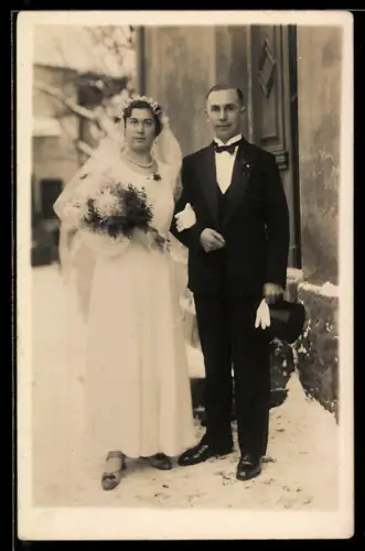 Foto-AK Elegantes Hochzeitspaar mit Brautstrauss vor einem Haus