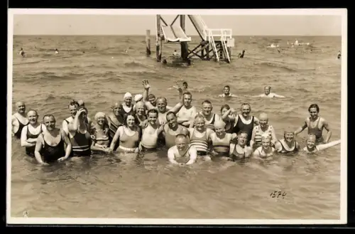 Foto-AK Gemischte Gruppe in Badeanzügen im flachen Wasser, Wasserrutsche