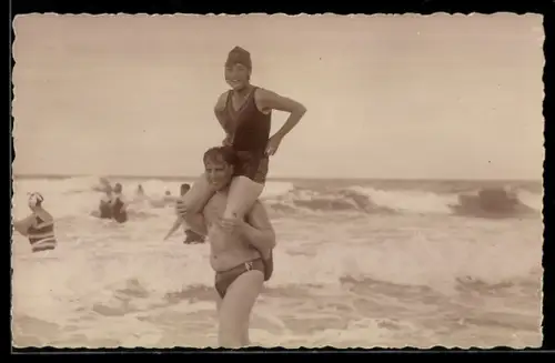 Foto-AK Paar in Badekleidung am Meer, Huckepack