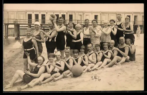 Foto-AK Damen und Herren in Badeanzügen beim Spiel am Strand, Badehäuser