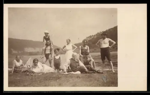 Foto-AK Gemischte Gruppe beim Sonnenbad an einem See, Badeanzug