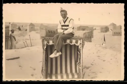 Foto-AK Sportlich gekleideter Herr auf einem Strandkorb, Strandpanorama