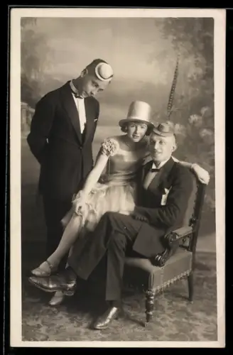 AK Frau sitzt auf dem Schoss eines Mannes, daneben ein jüngerer Mann mit kleinem Hut zum Fasching