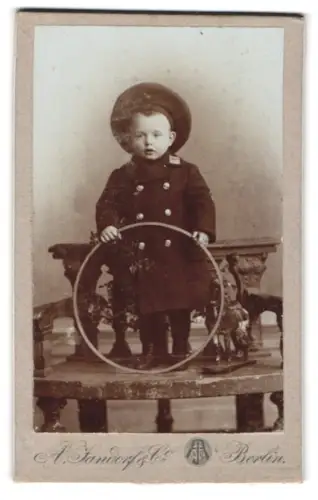 Fotografie A. Handorf & Co., Berlin, Bellealliancestr. 1/2, Kleinkind mit Hut und Reifen