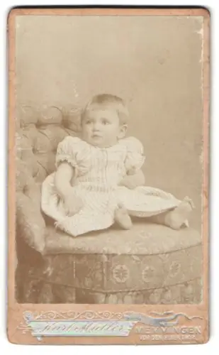 Fotografie Karl Müller, Memmingen, Vor dem Ulmerthor, sitzendes Kleinkind auf Sessel