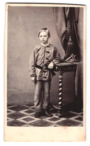 Fotografie A. F. Knoop, Eutin, Junge an einem Tisch lehnend