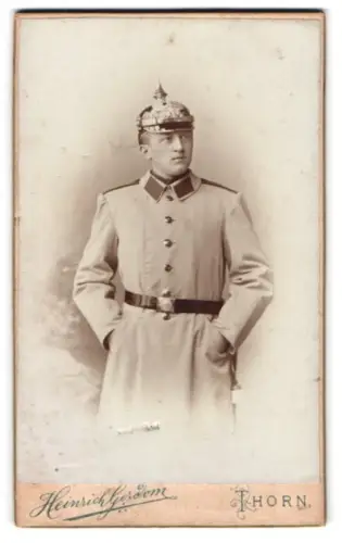 Fotografie Heinrich Gerdom, Thorn, Katharinenstr. 8, Soldat im Uniformmantel mit Pickelhaube und Seitenwaffe