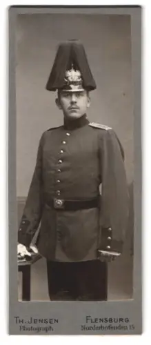 Fotografie Th. Jensen, Flensburg, Norderhofenden 15, Soldat in Uniform mit Paradehelm
