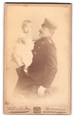 Fotografie Selle & Kuntze, Potsdam, Schwertfegerstr. 14, Offizier im Überrock mit Schirmmütze und Kleinkind