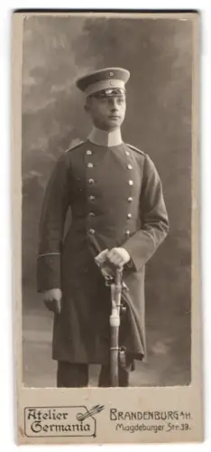 Fotografie Atelier Germania, Brandenburg a. H., Magdeburger Str. 39, Leutnant Bochow im Mantel mit Schirmmütze u. Säbel