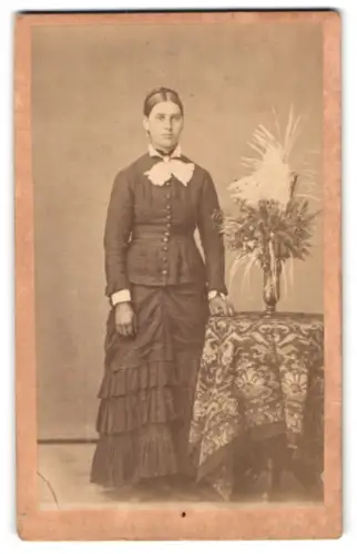 Fotografie unbekannter Fotograf und Ort, Frau mit dekorativem Tisch und Blumenarrangement