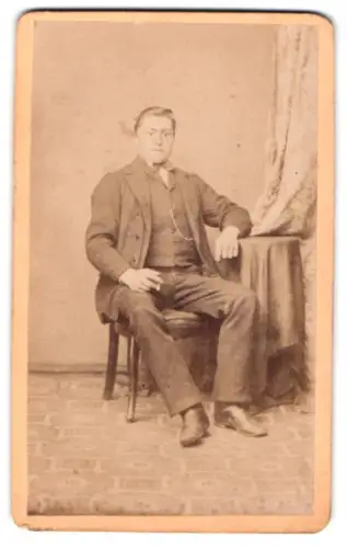 Fotografie Oswald Steubach, Hamburg-St. Pauli, Spielbudenplatz 24, Herr im Anzug auf Stuhl