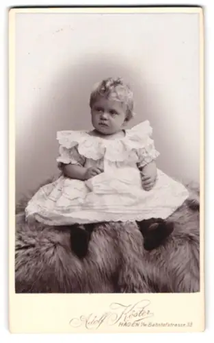Fotografie Adolf Köster, Hagen, Bahnhofstrasse 33, sitzendes Kleinkind mit Rüschenkleid