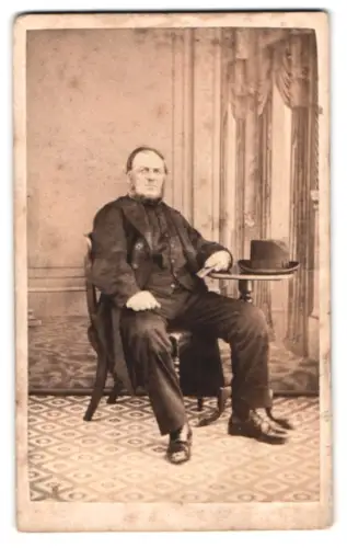 Fotografie John Williams, Bangor, Mann sitzend an kleinem Tisch