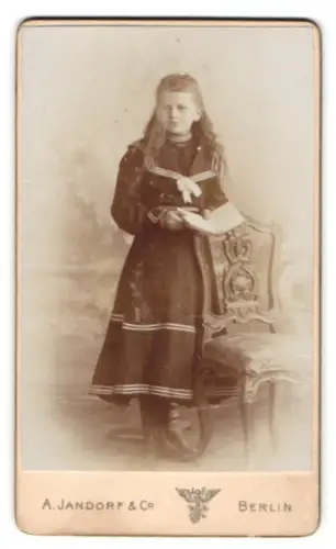 Fotografie A. Jandorf & Co., Berlin, Leipzigerstrasse 64, Mädchen mit Buch neben Stuhl