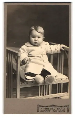 Fotografie H. Friebel-Sahli, Sursee, Bahnhofstrasse, Kleinkind auf Stuhl