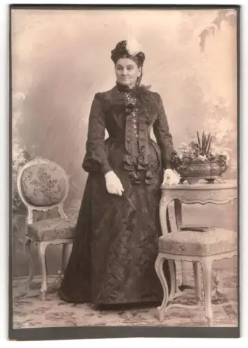 Fotografie F.X. Ostermayr, München, Karlsplatz 6, elegante Dame mit dekorativem Tisch und Stühlen