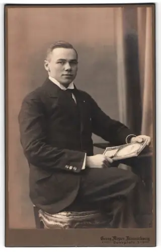 Fotografie Georg Meyer, Braunschweig, Bankplatz 3, Eleganter junger Mann mit gerahmtem Bild