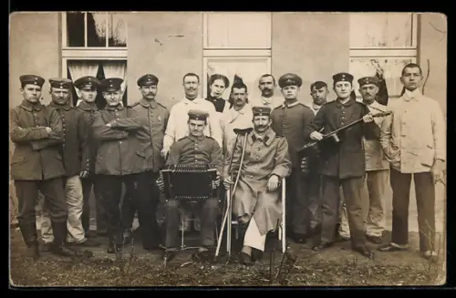 Foto-AK Im Lazarett, Personal und Patienten, Akkordeon, Gitarre, Krücke, Gruppenfoto 1915, Rotes Kreuz