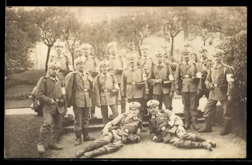 Foto-AK Sanitätssoldaten mit Rotkreuz-Armbinden u. -Kragenspiegeln in einem Park