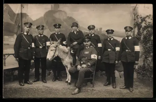 Foto-AK Sanitätssoldaten mit Rotkreuz-Armbinden u. -Kragenspiegeln, Gruppenforo mit Esel