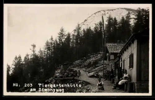 AK Tiergartenhütte am Simonyweg, Leute davor auf Bank und an Tischen