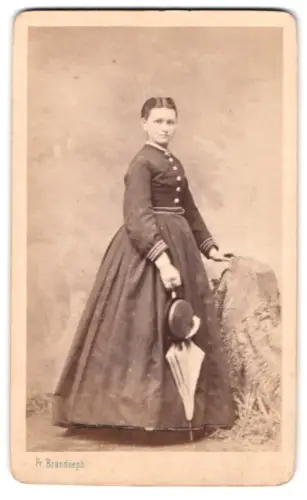 Fotografie Fr. Brandseph, Stuttgart, Frau im eleganten Kleid mit Hut und Regenschirm
