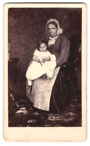 Fotografie unbekannter Fotograf und Ort, Frau mit Kind auf Stuhl