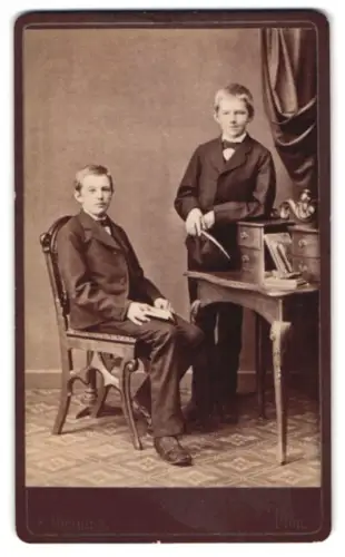 Fotografie F. Henning, Plön, Schlossberg, Zwei Jungen im Anzug an einem Tisch