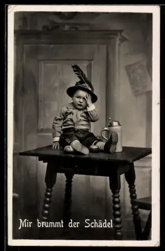 AK Kleiner Junge in Lederhosen, neben Bierkrug auf dem Tisch, Mir brummt der Schädel