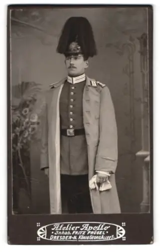 Fotografie Atelier Apollo, Dresden, König Georg-Allee 1, Sächsischer Garde-Soldat im Mantel mit Paradehelm