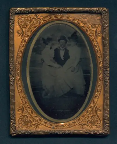 Fotografie Ferrotypie unbekannter Fotograf und Ort, Herr im Anzug mit Zylinder in Begleitung von zwei Damen, 1900