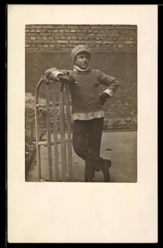 AK Junger Mann mit Zigarette neben einem Schlitten