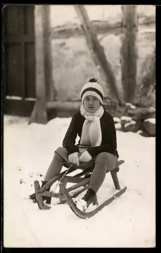 Foto-AK Kind sitzt auf einem Schlitten