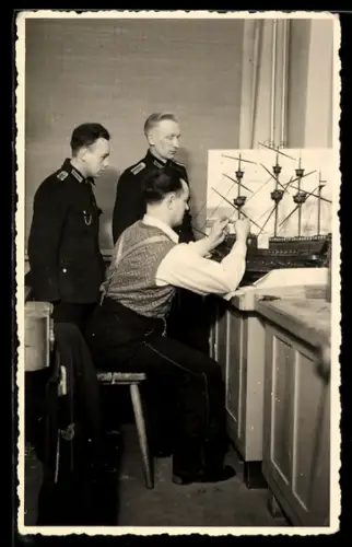 Foto-AK Soldaten beobachten einen Mann beim Bauen eines Schiffsmodells