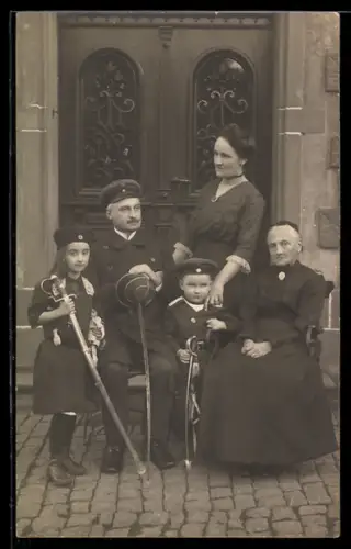 Foto-AK Kinder mit Säbeln und in Uniform mit ihrer Familie, Kinder Kriegspropaganda