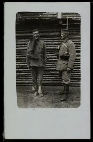 Foto-AK Kriegsgefangener neben einem Soldaten mit Gewehr